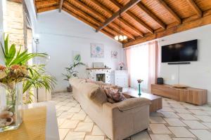 a living room with a couch and a flat screen tv at Villa Neon Tenerife in Arona