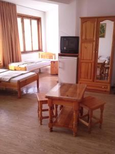 a living room with a table and a tv in it at Guest House Dzhegosh in Primorsko