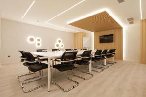 une salle de conférence avec une grande table et des chaises dans l'établissement LUX&EASY Signature Syggrou 234, à Athènes