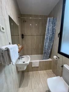 a bathroom with a sink and a tub and a toilet at Hostal Avenida in Madrid