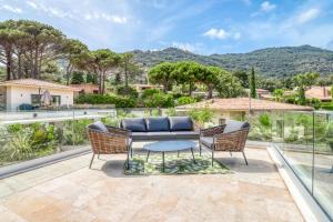 a patio with a table and chairs and a view at Akwabay - Les Villas du Cap in Le Lavandou