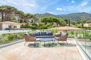 um pátio com uma mesa e cadeiras e uma vista em Akwabay - Les Villas du Cap em Le Lavandou