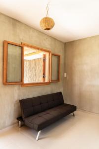 ガヴドスにあるExoristoi Nature Suitesの窓付きの客室で、黒いソファが備わります。