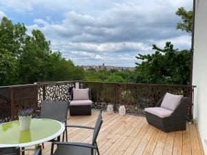 a balcony with a table and chairs on a wooden deck at Apt Luci Proche Clermont in Beaumont