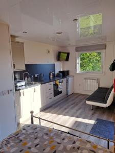 a kitchen with white cabinets and a couch in a room at The Posh Bothy Spean Bridge in Fort William