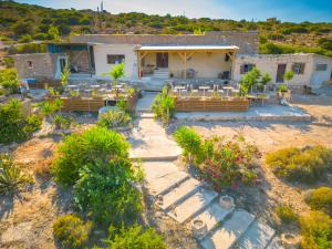 una vista aérea de una casa con mesas y sillas en Exoristoi Nature Suites en Gavdos