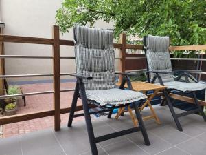 twee stoelen en een tafel op een patio bij Apartament Pod Orzechem in Bydgoszcz