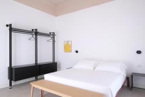 拉斯佩齊亞的住宿－Casa Umbertina，白色卧室设有床和木板凳