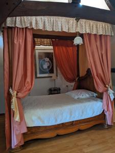 a bedroom with a canopy bed with pink curtains at Chambre d'hôtes Saint Jacob Relais de Chasse du XVIII Siècle in Les Fougerêts