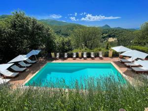 einen Pool mit Liegestühlen und Sonnenschirmen in der Unterkunft Spoleto Splashcasa Piscinaslps 4wifidishwasher - very pretty setting nr pool in Strettura