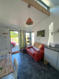 sala de estar con sofá rojo y mesa en Little Breoke en Lostwithiel