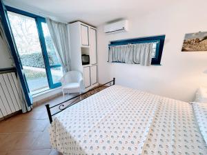 1 dormitorio con cama blanca y ventana en Spoleto Splashcasa Piscinaslps 4wifidishwasher - very pretty setting nr pool, en Strettura