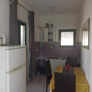 uma cozinha e sala de jantar com uma mesa e um frigorífico em Two peoples place em Petrcane