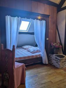 um pequeno quarto com uma cama e uma janela em Chambre d'hôtes Saint Jacob Relais de Chasse du XVIII Siècle em Les Fougerêts