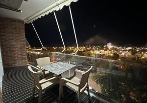 a table and chairs on a balcony at night at Fishta Apartments Q5 33 in Velipojë