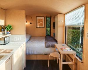 um pequeno quarto com uma cama numa pequena casa em Hut64 em Shootend