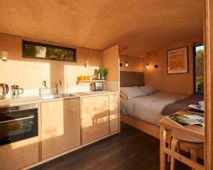 uma cozinha e um quarto com uma cama num quarto em Hut64 em Shootend