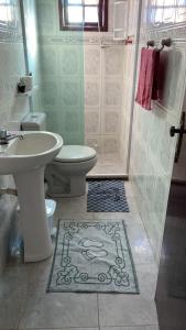 uma casa de banho com um lavatório, um WC e um chuveiro em Casa piscina 8 pessoas em Saquarema