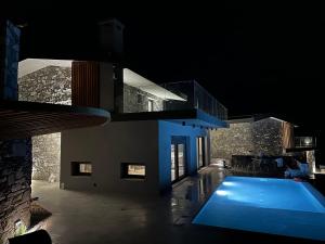 a house with a swimming pool at night at Windmills & The Villas-Aiolos ll in Amarynthos