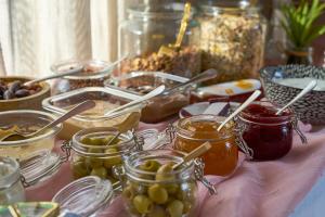 a table topped with jars of jam and olives at Dolcemente Garni Hotel Superior in Izola +27 photos
