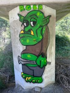 un cartel con un troll verde pintado en él en Conway River View Cottage For 2, en Cheviot