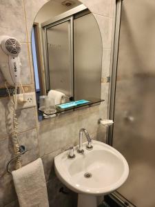 a bathroom with a sink and a mirror at Hotel Polans in Cipolletti