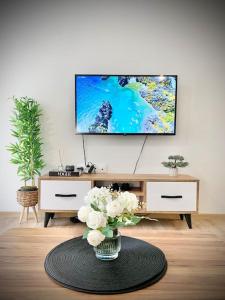a living room with a tv and a vase of flowers at Best Studio for Business & Family Super Fast WI-FI in Plovdiv