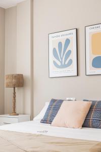 sypialnia z łóżkiem i 2 zdjęciami na ścianie w obiekcie Apartamentos Martalia Áticos Deluxe w mieście Ronda