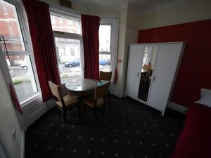 a room with a table and chairs and a window at Palm Beach Hotel in Bournemouth