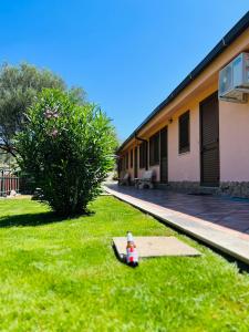 una boca de incendios sentada en el césped junto a un edificio en Agriturismo Sa Mandria, en Castiadas