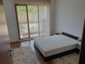 a bedroom with a bed and a large window at Panoramic Sea View Apartment in Byala