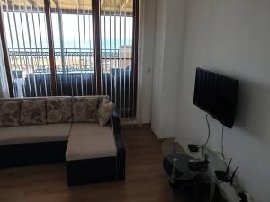 a living room with a couch and a flat screen tv at Panoramic Sea View Apartment in Byala