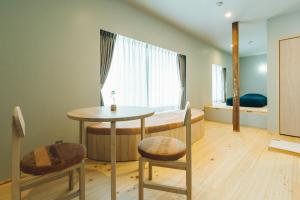 een kamer met een tafel, 2 stoelen en een bed bij 宿 ロイノハコ in Gotsu +32 foto's