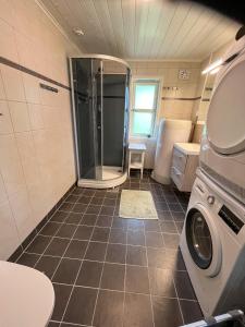a bathroom with a shower and a washing machine at Leilighet med flott uteplass in Ulefoss