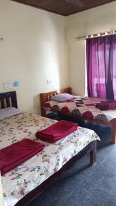 Habitación con 2 camas con sábanas rojas. en Gokarna Govekar Beach Stay, en Gokarn