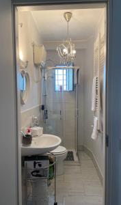 baño con lavabo, aseo y lámpara de araña en Appartamento Velletri centro en Velletri