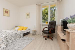 a bedroom with a bed and a chair and a window at Racławicka Cozy Studio Apartment by Renters in Warsaw