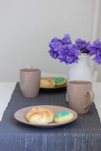 a table with a plate of donuts and two cups of coffee at Racławicka Cozy Studio Apartment by Renters in Warsaw