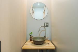 y baño con lavabo y espejo. en 宿 ロイノハコ en Gotsu