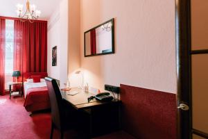 a hotel room with a desk and a bed at Hotel Der Schwan in Einbeck