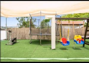a play area with swings and a canopy at אחוזת מלכי ישראל לשומרי שבת וכשרות in H̱osen