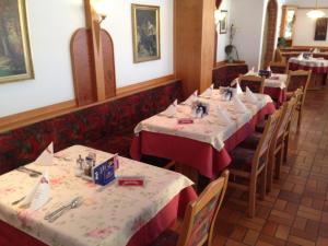 a row of tables in a restaurant with red table cloths at Hotel zum Kastell in Bad Tatzmannsdorf