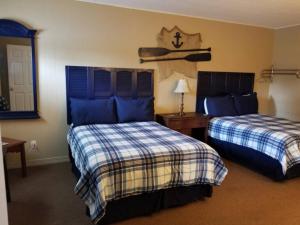 Cette chambre d'hôtel comprend 2 lits avec des draps bleus et blancs. dans l'établissement Sportsman's Lodge, à Fairfield Bay