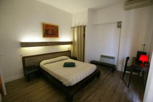 a bedroom with a bed and a table with a lamp at H&ocirc;tel U Pozzu in Sisco