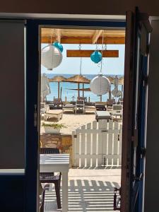 an open door to a beach with chairs and umbrellas at Melina's House 2 in Kardamaina