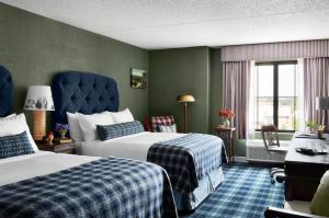 StorrsにあるGraduate Storrsのベッド2台と窓が備わるホテルルームです。