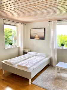 ein Schlafzimmer mit einem Bett und zwei Fenstern in der Unterkunft GG Village in Askim