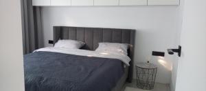 a bedroom with a bed with a blue comforter and pillows at New and comfortable apartments in Uzhhorod