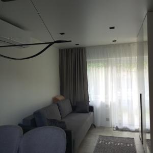 uma sala de estar com um sofá e uma grande janela em New and comfortable apartments em Uzhhorod