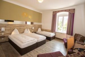 una habitación de hotel con 2 camas y una silla en Dollinger en Innsbruck